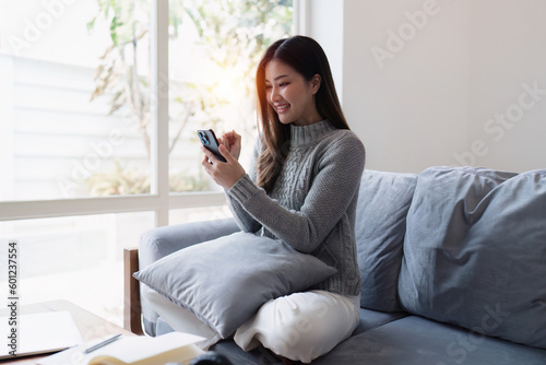 Attractive Asian woman resting comfortable living room and using mobile phone, Relax, Sofa, Lifestyle