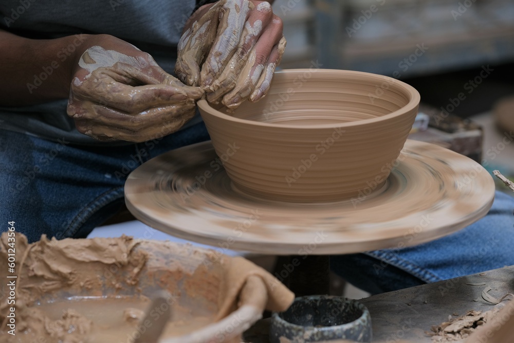 The process of making tableware product from clay. Craftman work at workshop. Pembuatan mangkok dan gelas dari tanah