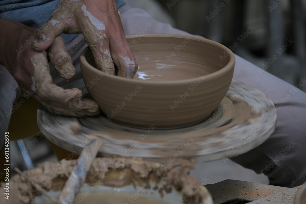 The process of making tableware product from clay. Craftman work at workshop. Pembuatan mangkok dan gelas dari tanah liat