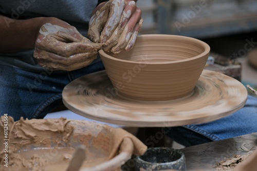 The process of making tableware product from clay. Craftman work at workshop. Pembuatan mangkok dan gelas dari tanah photo