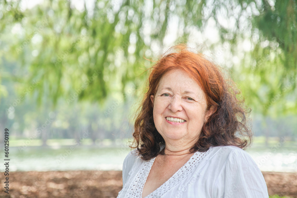 Portrait of a latin senior woman smiling carefree and looking at camera in nature. Bright composition with copy space. Concept: peace of mind and happiness enjoying leisure time during retirement. Portrait of a latin senior woman smiling carefree and looking at camera in nature. Bright composition with copy space. Concept: peace of mind and happiness enjoying leisure time during retirement.