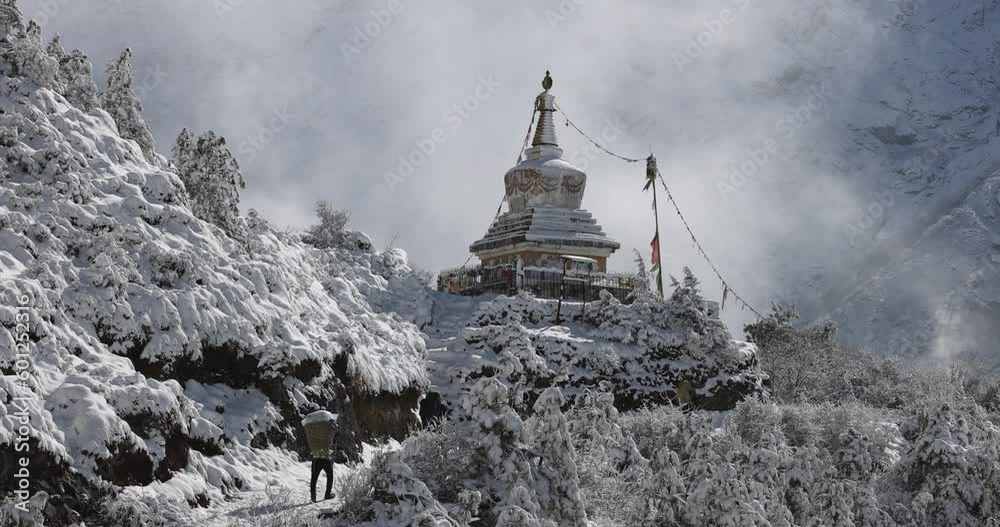 People porting goods to the mountains in Nepal along a snowy trail. People porting goods to the mountains in Nepal along a snowy trail.