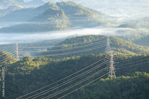 High voltage electric power tower in a green agricultural landscape at sunset photo