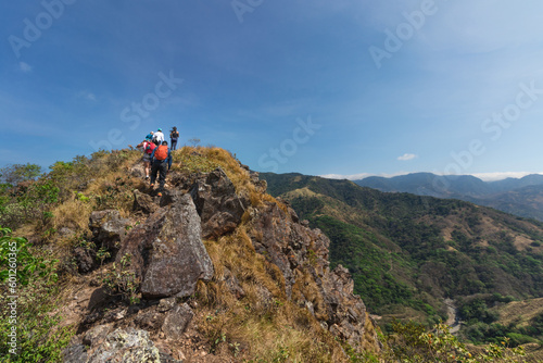 group of hikers walking along the edge of a hill on a hot sunny day in the province of Puntarenas in Costa Rica