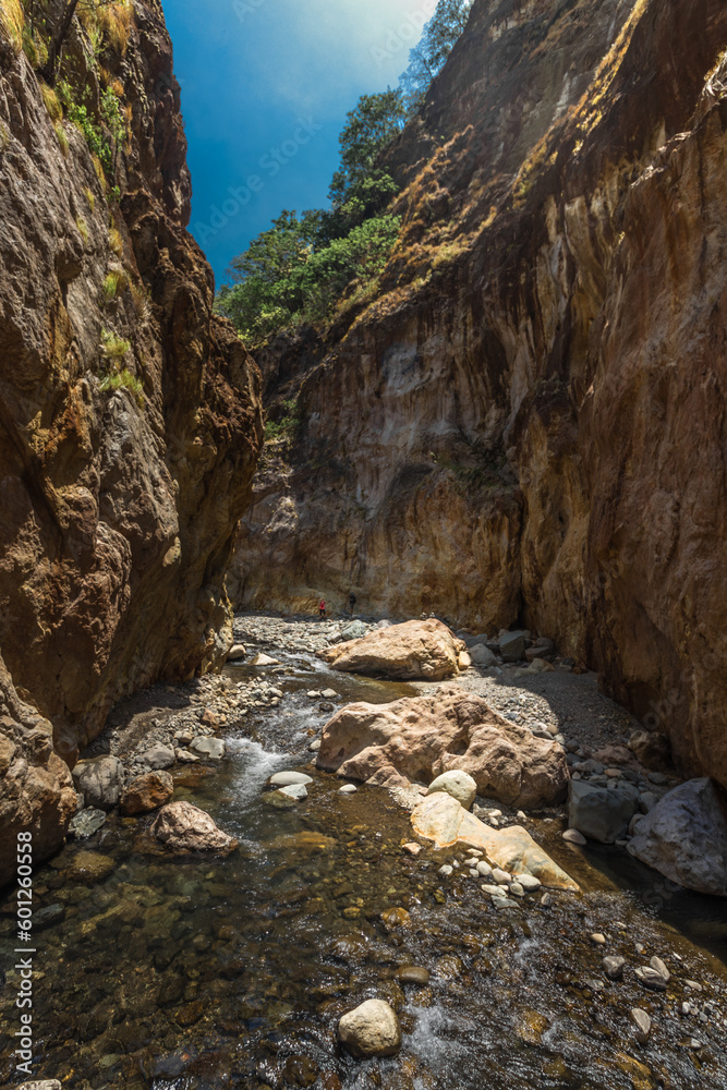 vertical shot of a landscape of a rocky canyon and the river bed on a hot sunny day in the province of Puntarenas in Costa Rica