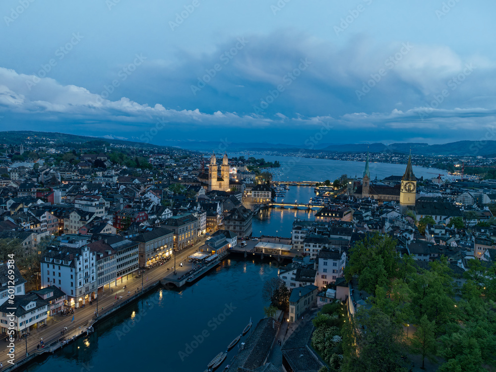 Fototapeta premium Aerial view over Swiss City of Zürich with Limmat River, old town and Lake Zurich on a beautiful spring evening with colorful dramatic sky. Photo taken May 6th, 2023, Zurich, Switzerland.