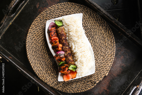 Chelo kabab or chello kebab with chicken tikka and rice served in dish isolated on red mat top view on table arabic food photo