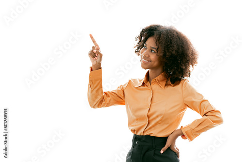 Beautiful young Afro American business woman in formal wear is pointing upward and smiling, isolated on white photo