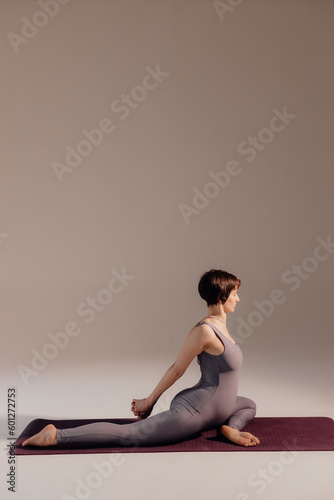 Young pregnant woman doing yoga exercises and meditating at studio. Health care, mindfulness and wellness concept.