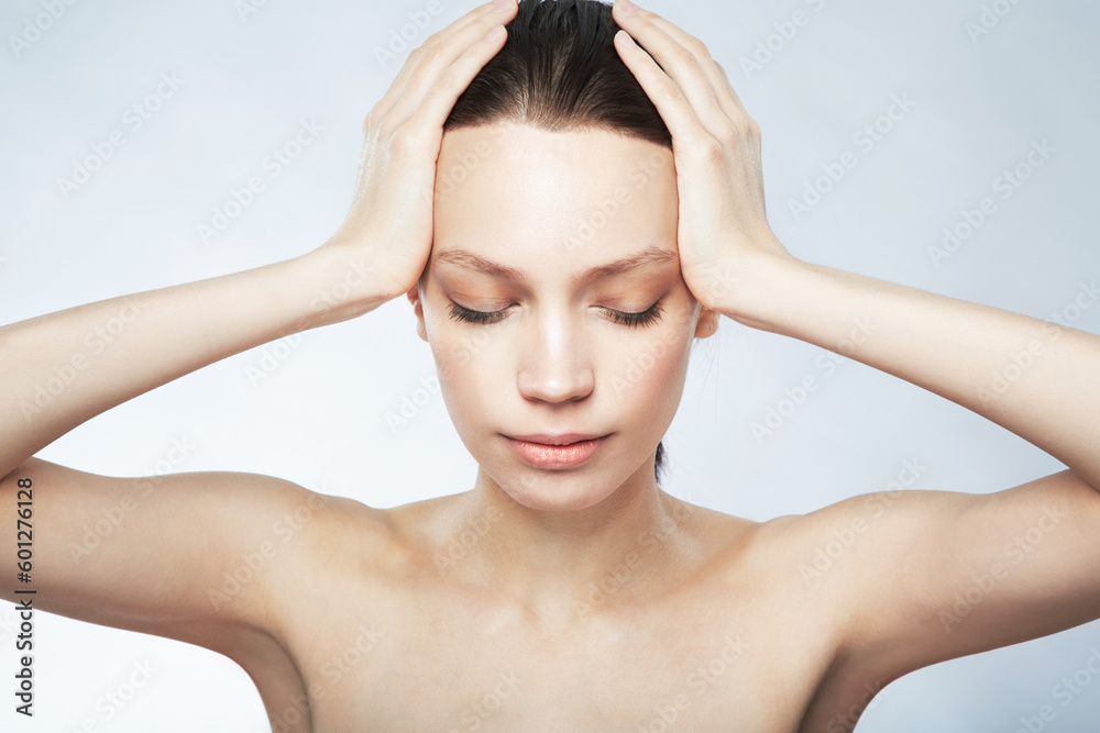 Naklejka premium Woman, beauty and hands on head for hair care, skincare or cosmetics treatment on gray studio background. Girl, face and closed eyes to relax at spa for scalp, body and facial massage or selfcare