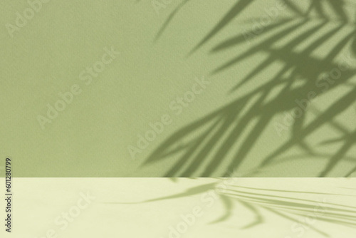 Minimal abstract background for the presentation of a cosmetic product. Empty premium podium with a shadow of tropical palm leaves on a green background. Showcase, display case.