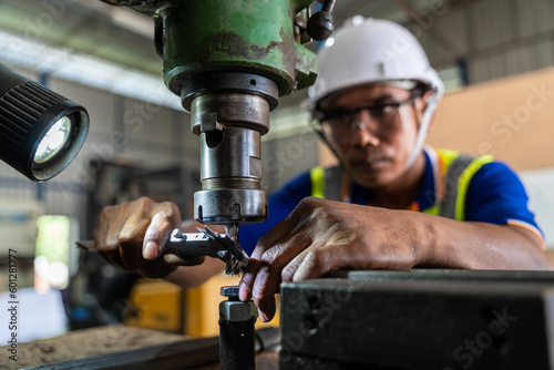 A worker wearing safety glasses working on a lathe machine. selective focus of Vernier at the lathe..