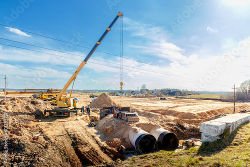 Connecting a trench drain to a concrete manhole structure at construction site. Concrete pile in formwork frame for construct stormwater and underground utilities, pump stations, sewers pipes photo