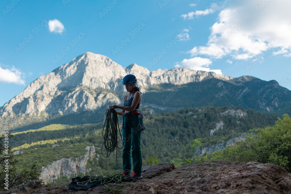 A rock climber prepares equipment for climbing