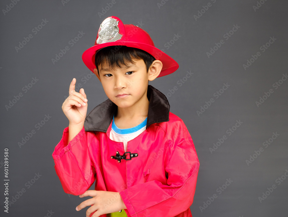 A young boy wearing a fireman hat and a red shirt. A young boy wearing a fireman hat and a red shirt.