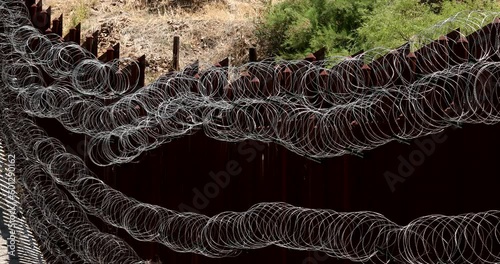 Daytime view of the fortified USA Mexico border wall as it runs through downtown Nogales, Arizona, USA. photo