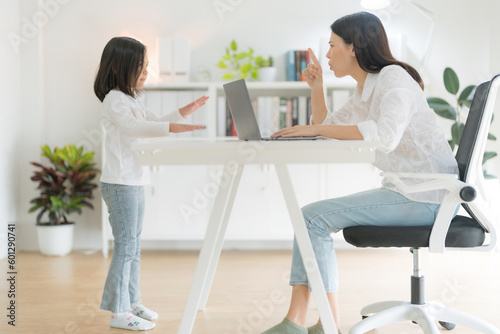 Mother trying to work at home office and daughter.
