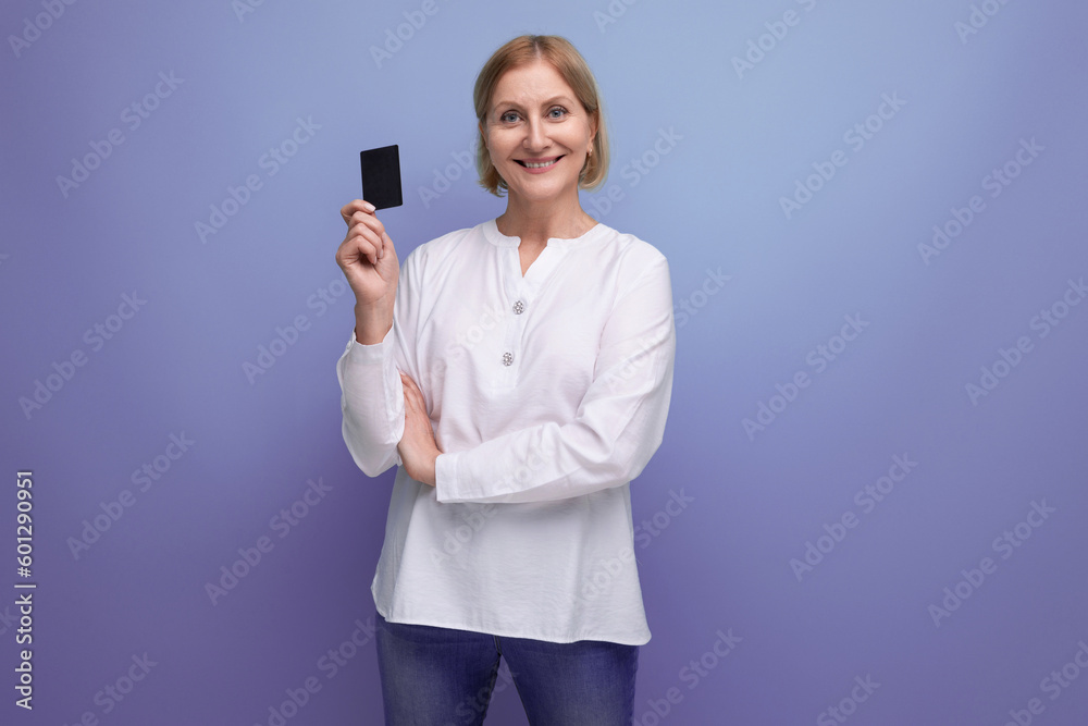 blonde 50s woman in white blouse holding card for payments with mocap on studio background blonde 50s woman in white blouse holding card for payments with mocap on studio background