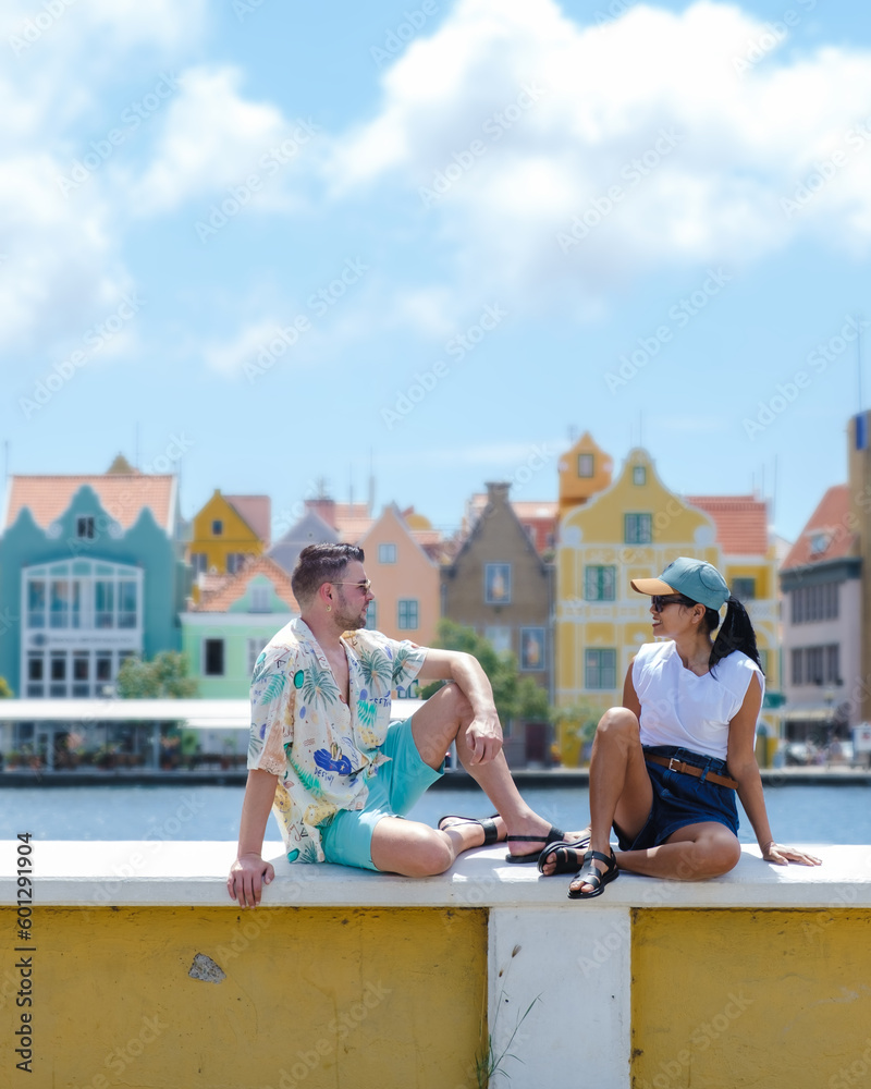 couple men and woman on vacation Curacao visiting Willemstad Curacao, colorful buildings around Willemstad Punda and Otrobanda, multicolored homes Curacao Caribean Island