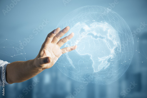 Close up of male hand using glowing polygonal globe on blurry city background. World map and earth concept.