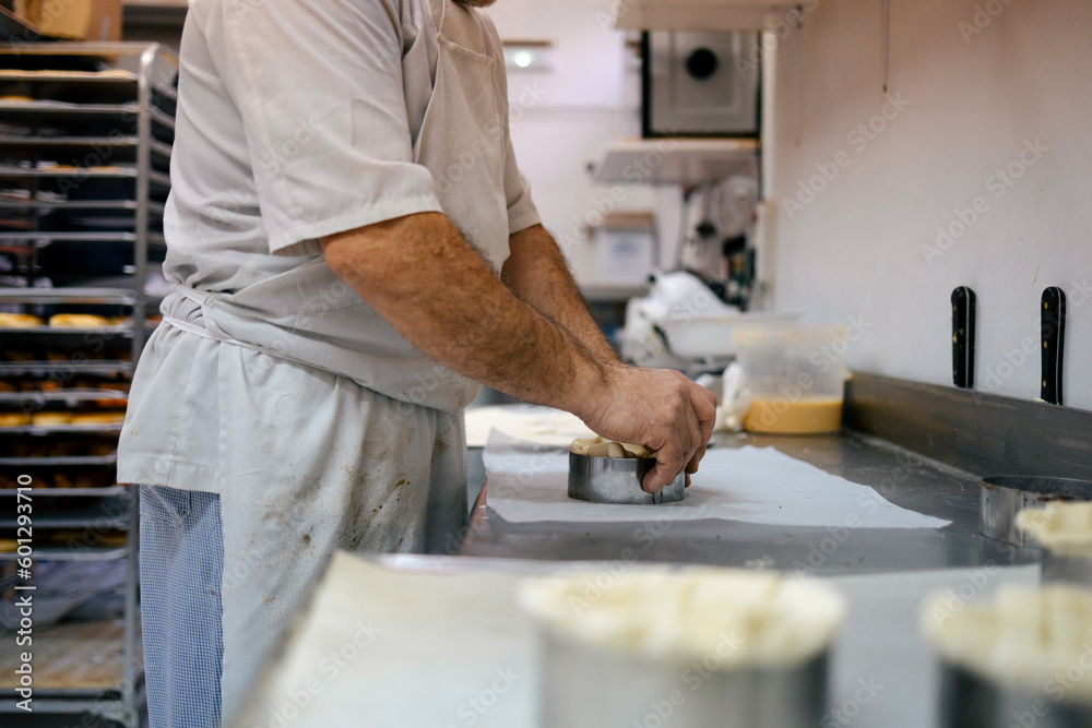 Unrecognizable pastry chef making cake