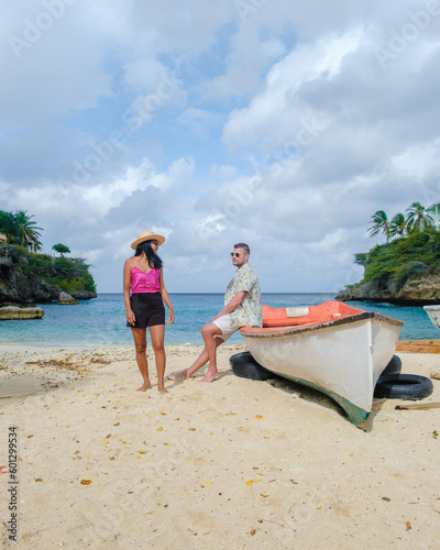 A couple of men and women in swimshorts and bikinis at Playa Lagun Beach Cliff Curacao, 