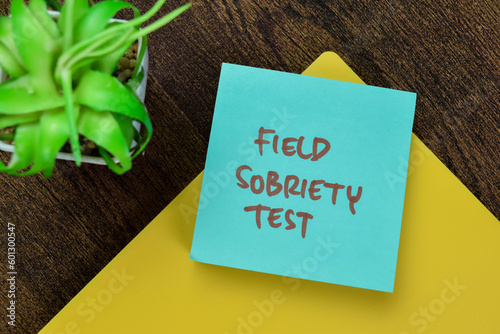 Concept of Field Sobriety Test write on sticky notes isolated on Wooden Table.