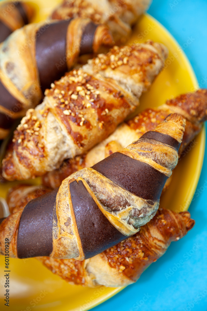Chocolate croissants or croissant with nut crumbs on a plate. Breakfast on the table. Sweet baking dessert for coffee.