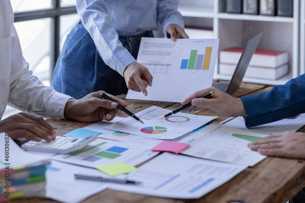 Group of confident business people point to graphs and charts to analyze market data, balance sheet, account, net profit to plan new sales strategies to increase production capacity. Group of confident business people point to graphs and charts to analyze market data, balance sheet, account, net profit to plan new sales strategies to increase production capacity.