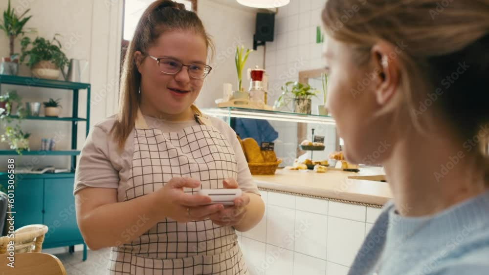 Caucasian man with down syndrome accepting contactless payment in the cafe. Shot with RED helium camera in 8K. Caucasian man with down syndrome accepting contactless payment in the cafe. Shot with RED helium camera in 8K.