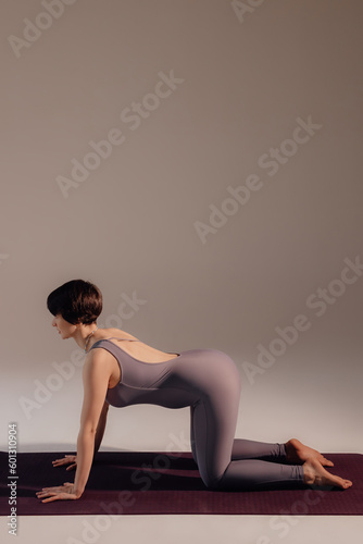 Young pregnant woman doing yoga exercises and meditating at studio. Health care, mindfulness and wellness concept.
