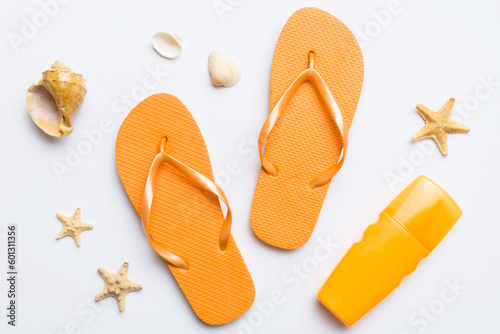 Flat lay composition with flip flops and seashell on colored background. Space for text top view