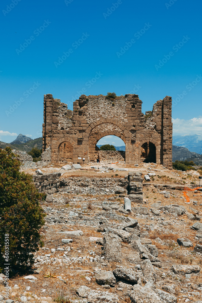 Aspendos archaeological site featuring the well-preserved amphitheater and arches, buildings in Side, Antalya, Turkey.