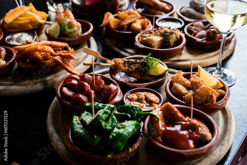Tapas Bowls with Food arranged on a Table in a Tapas Bar. photo
