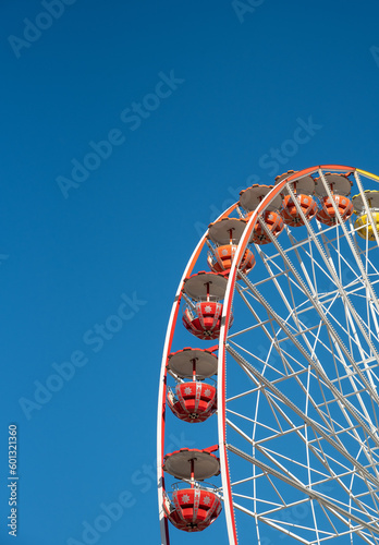 Multicolour ferris wheel isolated on blue sky background, Having fun on an amusement fairground park