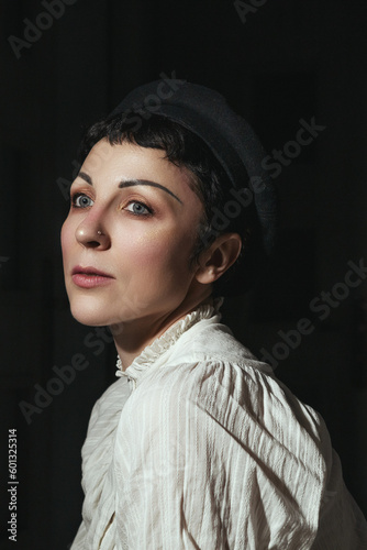 A woman in a white shirt and a black beret smiles at the camera.