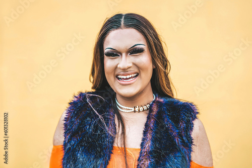 Happy drag queen smiling at camera on a yellow background - Trans man celebrating gay pride day - Lgbt community concept photo