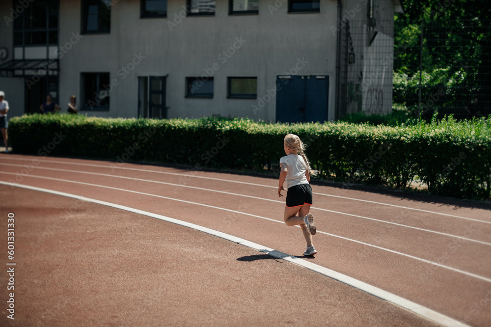 Obraz premium The girl runs a school marathon, the concept of a healthy lifestyle.