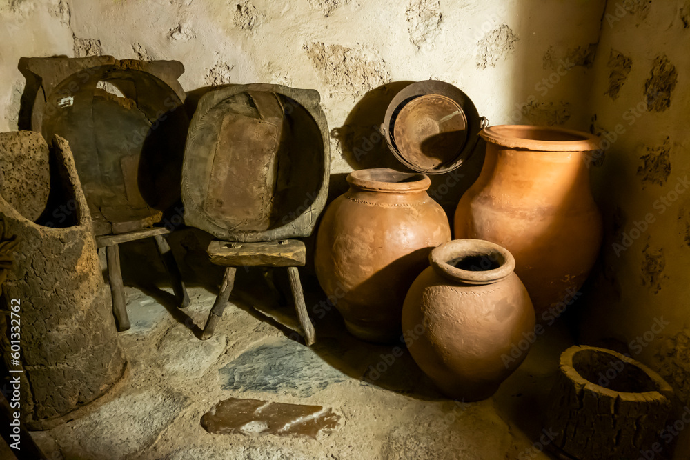 Old clay pots and wooden baskets in the pantry of traditional medieval kitchen in an old monastery or convent