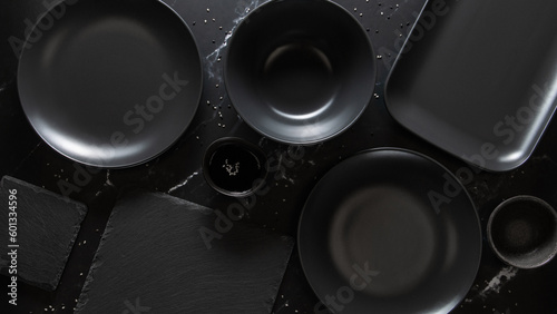 Dark empty plates without food on dark stone background, flat lay, top view.