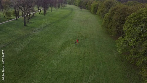 person with a red banner stands alone in a park photo