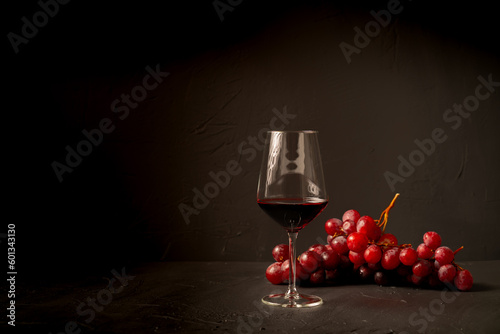 Tableau sur toile Glass red wine and grapes on black background.