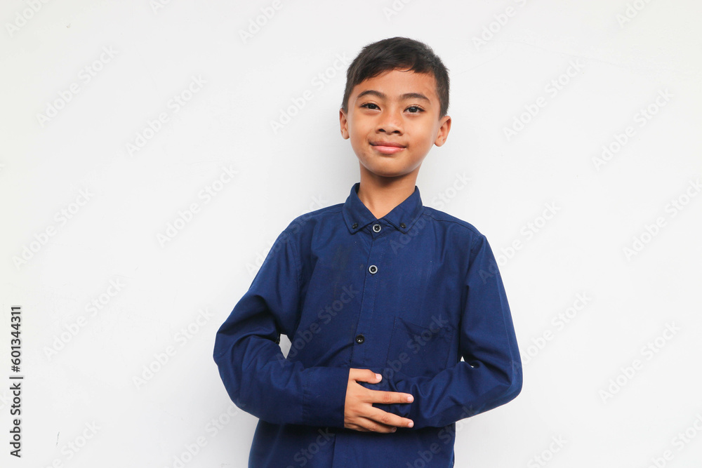 Smiling boy in blue shirt looking at the camera while put hands on the comfort belly Smiling boy in blue shirt looking at the camera while put hands on the comfort belly