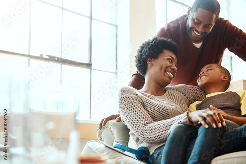 Happy, love and family bonding on a sofa together in the living room of their modern house. Happiness, smile and African parents spending quality time, talking and relaxing with her boy child at home photo