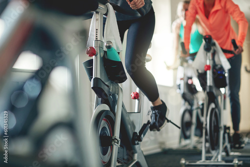 Fotografía Fitness, legs and exercise bike with people in a gym for a cardio or endurance spinning class workout