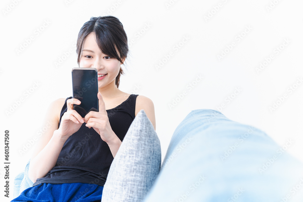 Fototapeta premium 下着を着てスマホを使う若い女性