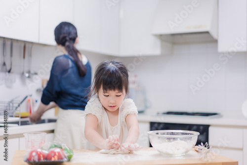 料理を手伝う女の子とお母さん