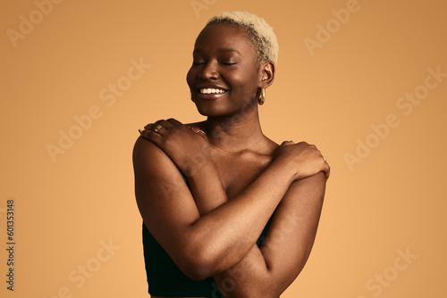 Nude black woman hiding breast with hands