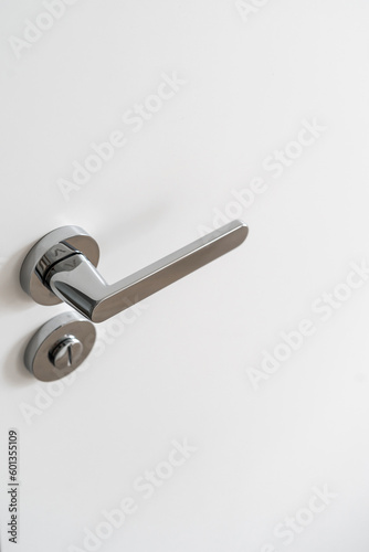 Aluminum doorknob and lock on the white door © brizmaker