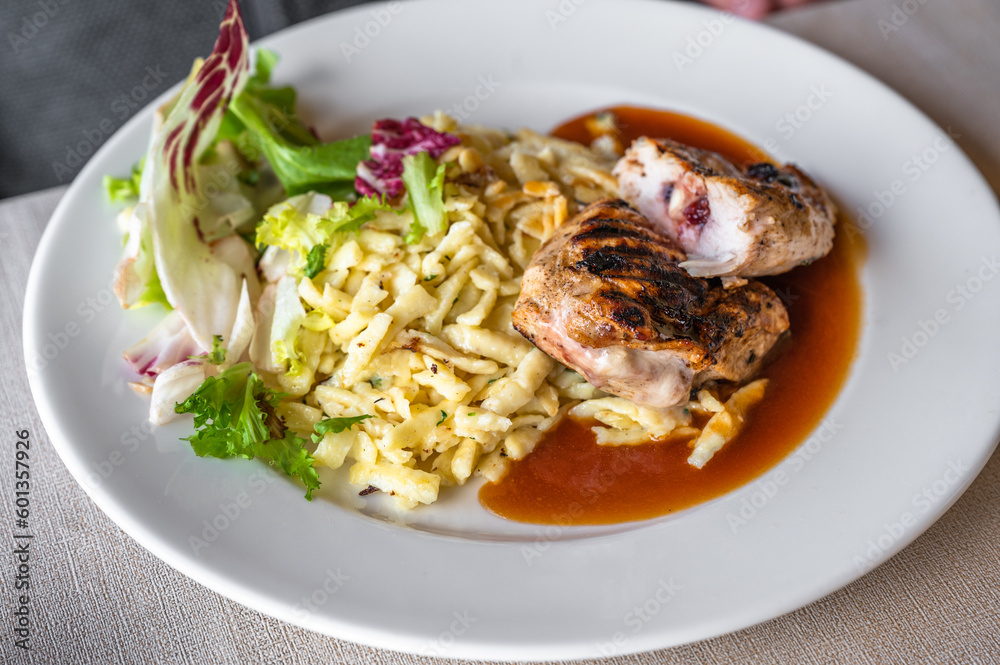 Spetzle (egg noodle) with fried stuffed chicken meat with cheese and cranberry. Spetzle (egg noodle) with fried stuffed chicken meat with cheese and cranberry.